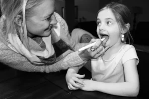 young girl being shown how to position tongue
